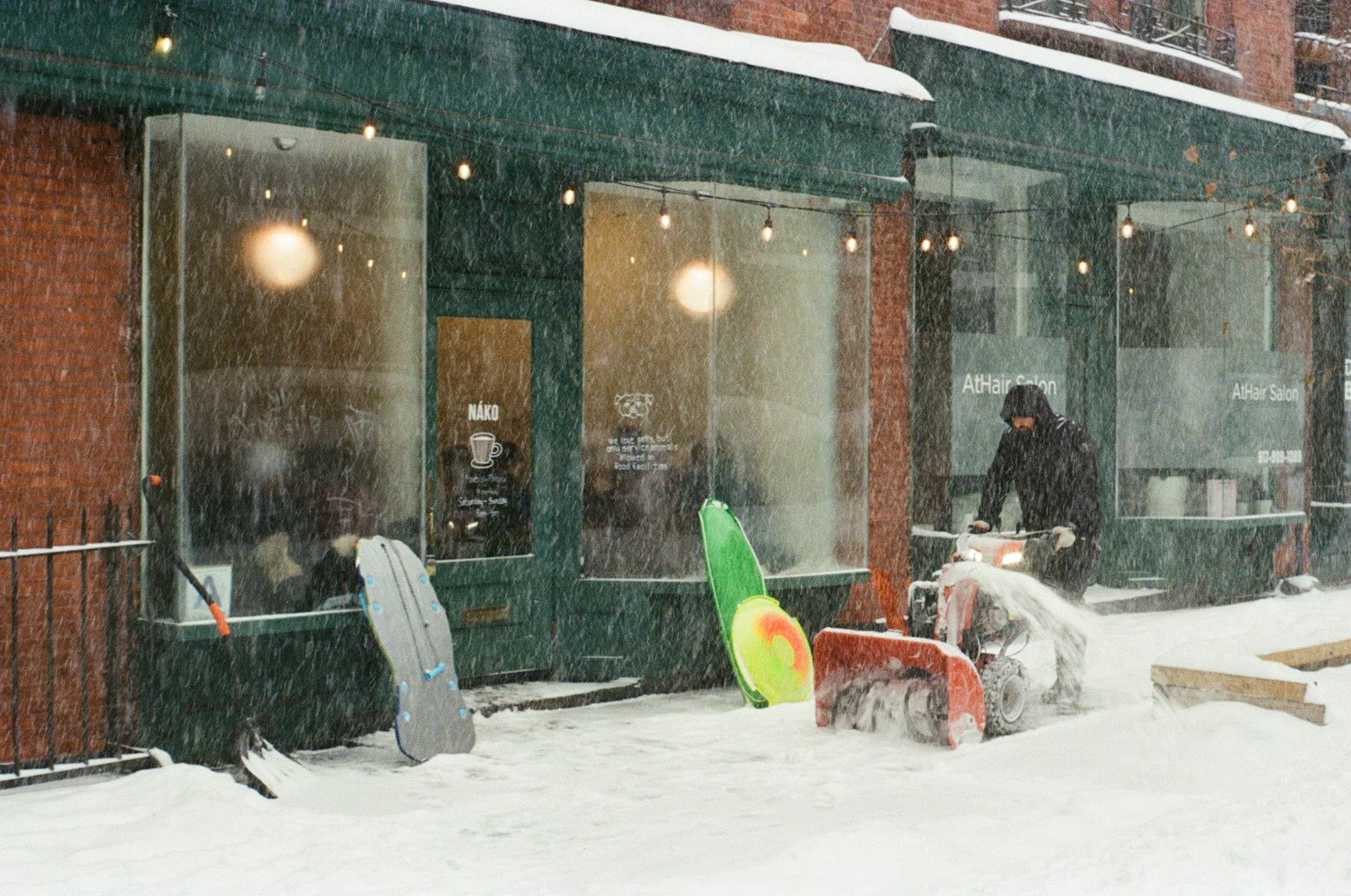 Commercial snow removal Freehold NJ: clearing a storefront sidewalk by hand during a storm